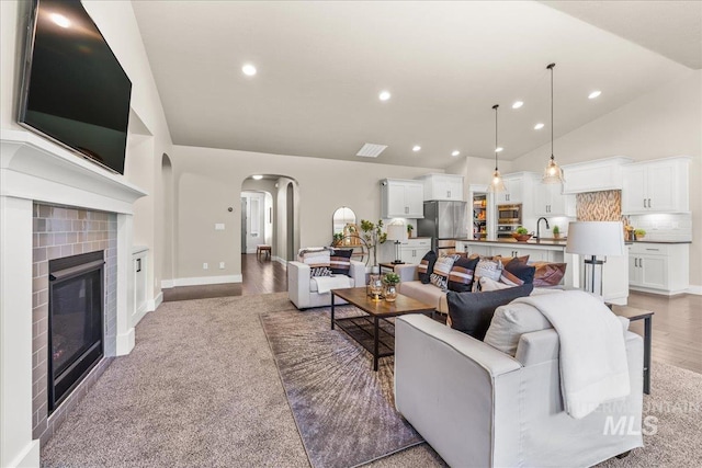 495 W Tall Prairie Dr, Meridian, ID 83642 - living room featuring arched walkways, lofted ceiling, recessed lighting, light wood-style floors, and a tile fireplace