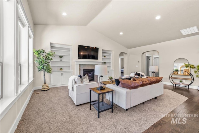 495 W Tall Prairie Dr, Meridian, ID 83642 - living room with arched walkways, vaulted ceiling, a brick fireplace, healthy amount of natural light, and built in shelves