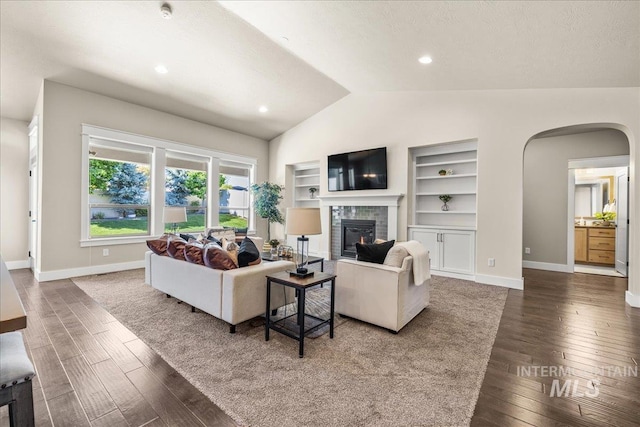 495 W Tall Prairie Dr, Meridian, ID 83642 - living area featuring arched walkways, lofted ceiling, wood finished floors, a fireplace, and built in shelves