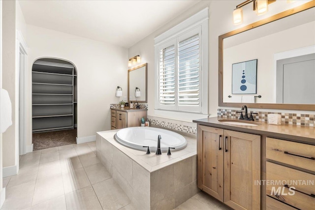 495 W Tall Prairie Dr, Meridian, ID 83642 - full bath featuring a bath, two vanities, backsplash, baseboards, and tile patterned flooring