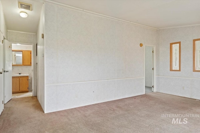unfurnished room featuring ornamental molding, light carpet, and visible vents