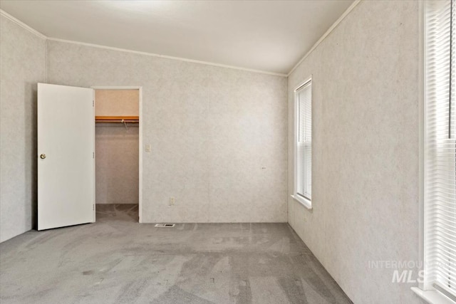 unfurnished bedroom with ornamental molding, carpet flooring, and multiple windows