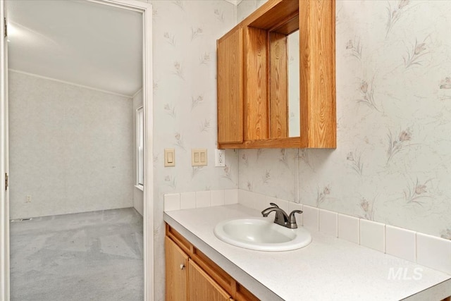 bathroom featuring wallpapered walls and vanity