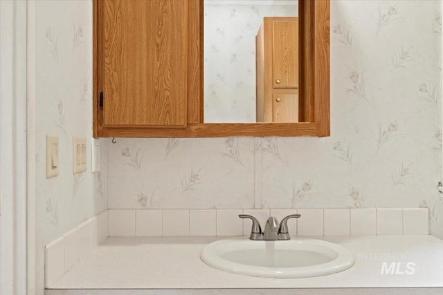 bathroom with wallpapered walls and vanity