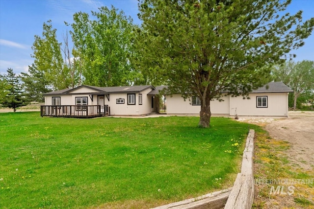 back of house featuring a yard and a wooden deck