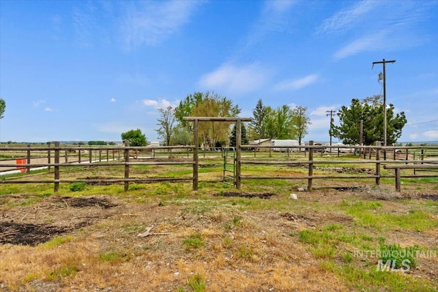 view of yard with a rural view and fence
