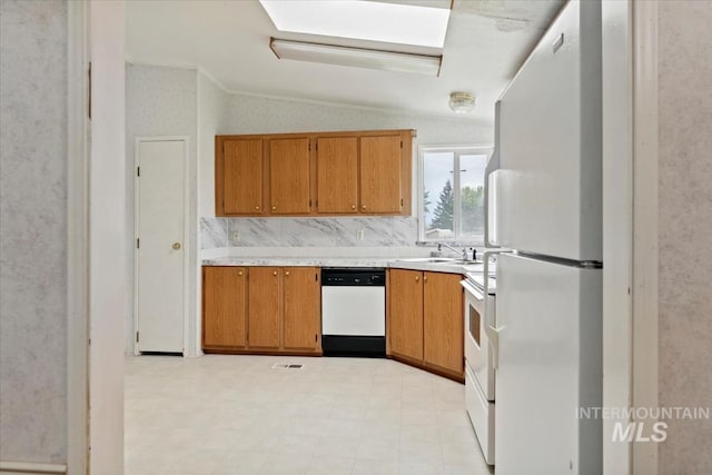 kitchen with brown cabinets, a sink, white appliances, light countertops, and lofted ceiling