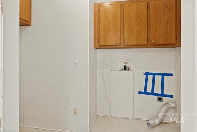 clothes washing area featuring light tile patterned floors, hookup for a washing machine, cabinet space, and electric dryer hookup