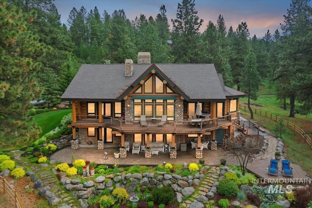 1533 Pine Lakes Ranch Dr, Cascade, ID 83611 - rear view of house featuring stone siding, a patio, a chimney, log exterior, and stairway