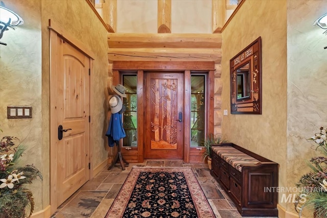 1533 Pine Lakes Ranch Dr, Cascade, ID 83611 - foyer entrance featuring stone tile flooring, a towering ceiling, and a textured wall