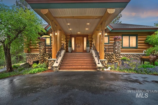 1533 Pine Lakes Ranch Dr, Cascade, ID 83611 - property entrance featuring log siding, covered porch, and roof with shingles