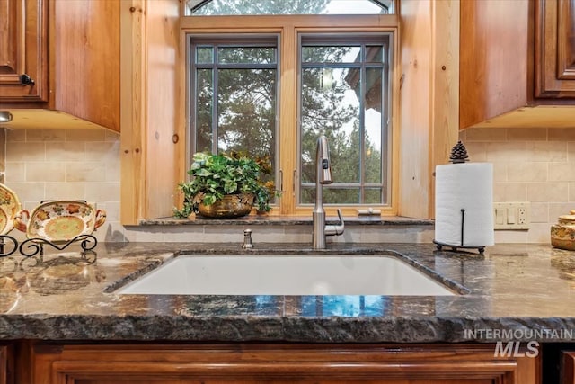 1533 Pine Lakes Ranch Dr, Cascade, ID 83611 - kitchen view of brown cabinets, dark stone countertops, and decorative backsplash