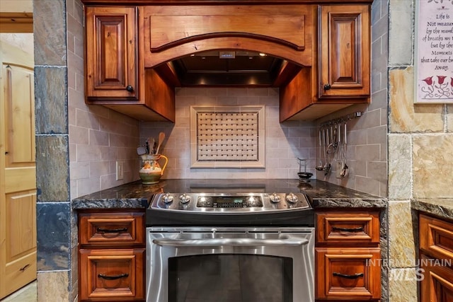 1533 Pine Lakes Ranch Dr, Cascade, ID 83611 - kitchen featuring stainless steel range with electric cooktop, custom exhaust hood, tasteful backsplash, and brown cabinetry