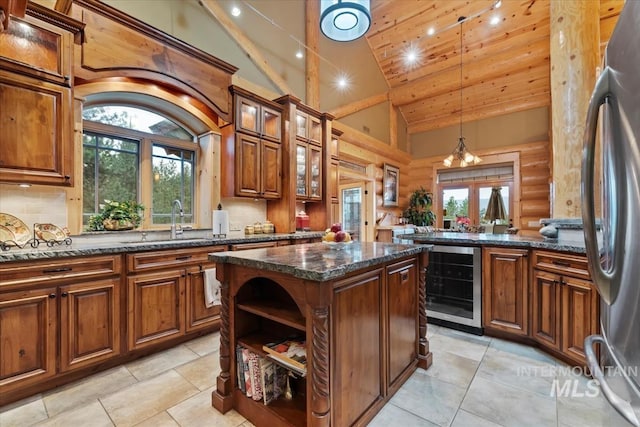 1533 Pine Lakes Ranch Dr, Cascade, ID 83611 - kitchen featuring beverage cooler, a center island, freestanding refrigerator, high vaulted ceiling, and brown cabinets