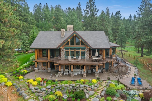 1533 Pine Lakes Ranch Dr, Cascade, ID 83611 - rear view of house with stone siding, log siding, a chimney, and a patio