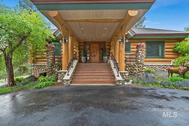 1533 Pine Lakes Ranch Dr, Cascade, ID 83611 - view of exterior entry featuring log exterior, covered porch, and a shingled roof
