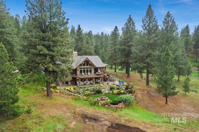 1533 Pine Lakes Ranch Dr, Cascade, ID 83611 - back of property with a wooden deck, a forest view, a chimney, and stairs