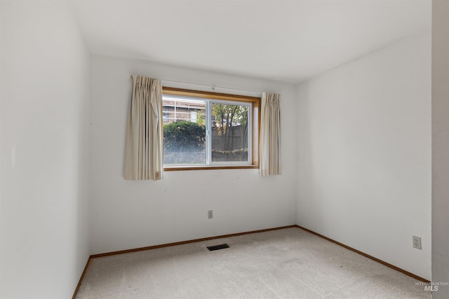 unfurnished room featuring carpet, visible vents, and baseboards