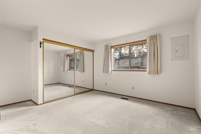 unfurnished bedroom featuring carpet floors, electric panel, visible vents, and baseboards