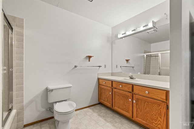 bathroom with shower / bath combination with glass door, toilet, vanity, baseboards, and tile patterned floors