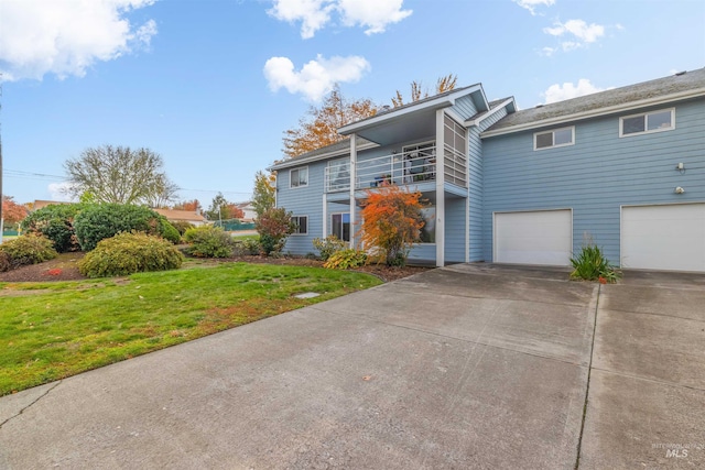 exterior space with a balcony, a lawn, driveway, and an attached garage