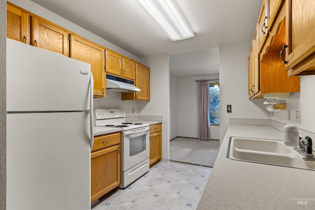 kitchen with light floors, light countertops, a sink, white appliances, and under cabinet range hood