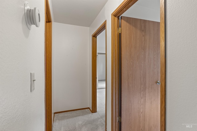 hallway featuring carpet floors and baseboards