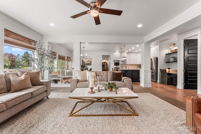 1912 N Bottle Creek Pl, Eagle, ID 83616 - living room with ceiling fan, recessed lighting, a chandelier, light colored carpet, and light wood-style floors