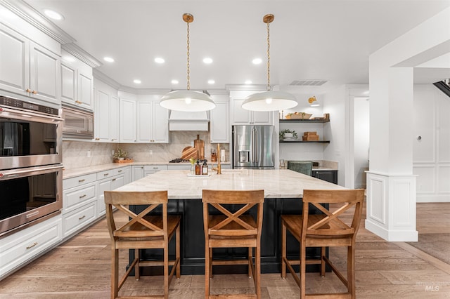 1912 N Bottle Creek Pl, Eagle, ID 83616 - kitchen with appliances with stainless steel finishes, decorative backsplash, open shelves, an island with sink, and a breakfast bar