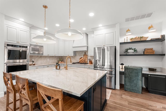 1912 N Bottle Creek Pl, Eagle, ID 83616 - kitchen with appliances with stainless steel finishes, custom range hood, white cabinets, a kitchen breakfast bar, and recessed lighting