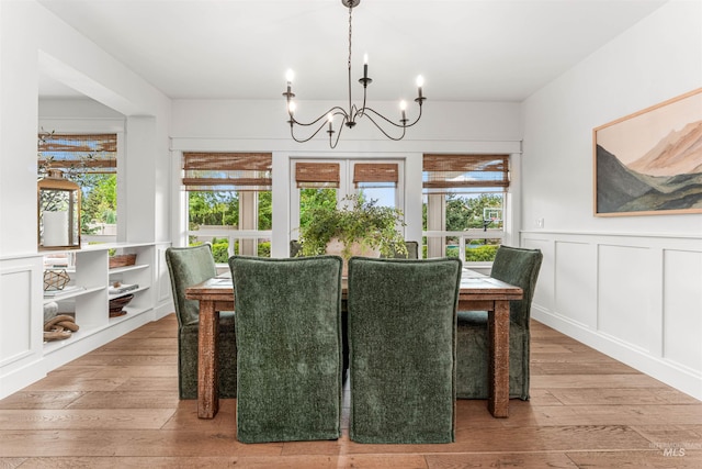 1912 N Bottle Creek Pl, Eagle, ID 83616 - dining space with a chandelier, wood-type flooring, a wainscoted wall, and a decorative wall
