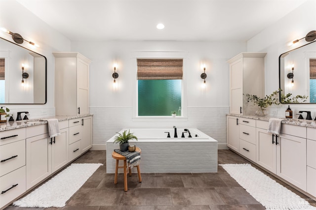 1912 N Bottle Creek Pl, Eagle, ID 83616 - bathroom with two vanities, a bath, a wainscoted wall, and recessed lighting