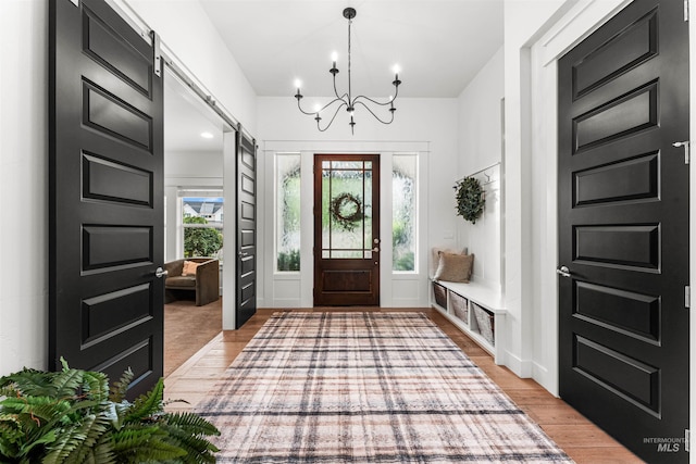 1912 N Bottle Creek Pl, Eagle, ID 83616 - foyer with a barn door, a chandelier, and light wood-style flooring