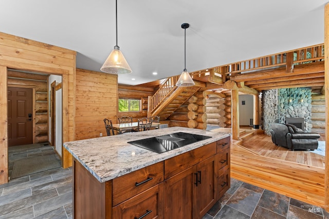 881 Sheila, Mccall, ID 83638 - kitchen featuring log walls, black electric cooktop, light stone counters, hanging light fixtures, and dark stone finish floors