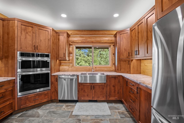 881 Sheila, Mccall, ID 83638 - kitchen featuring stainless steel appliances, light stone countertops, dark stone finish floors, brown cabinetry, and recessed lighting