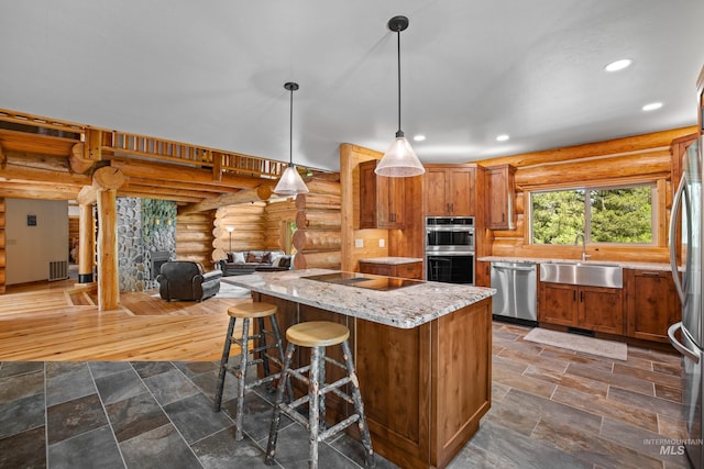 881 Sheila, Mccall, ID 83638 - kitchen featuring appliances with stainless steel finishes, log walls, a kitchen island, light stone countertops, and brown cabinetry