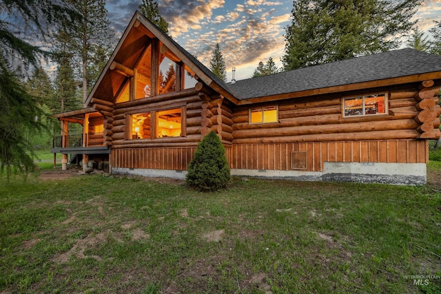 881 Sheila, Mccall, ID 83638 - back of house at dusk with log siding, a yard, and roof with shingles