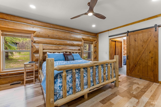 881 Sheila, Mccall, ID 83638 - bedroom with recessed lighting, a barn door, log walls, and light wood-type flooring