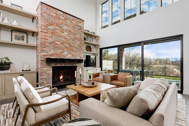 living area featuring a wealth of natural light, a brick fireplace, and wood finished floors