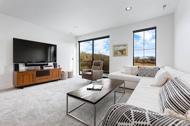 living room with recessed lighting, visible vents, baseboards, and light colored carpet