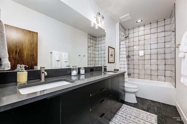 bathroom featuring double vanity, tub / shower combination, toilet, and a sink