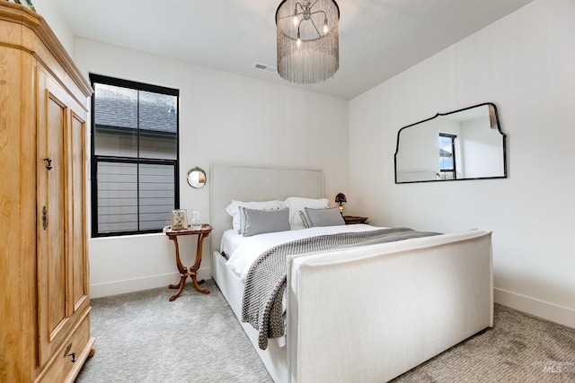 carpeted bedroom with visible vents, baseboards, and an inviting chandelier