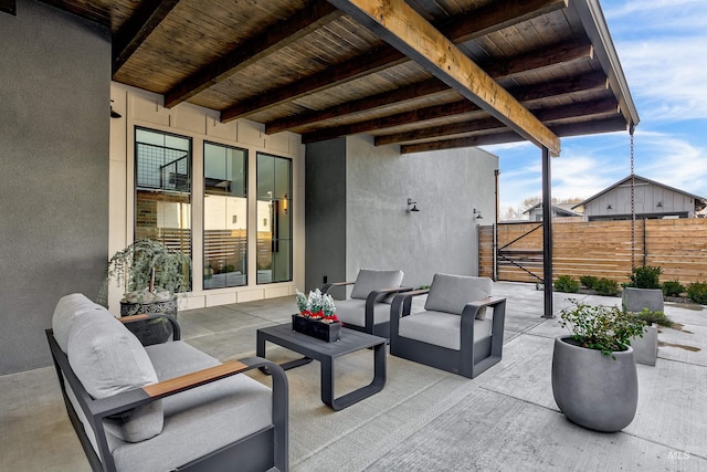 view of patio featuring a gate, outdoor lounge area, and fence