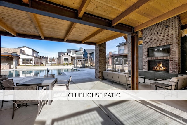 view of patio / terrace with an outdoor living space with a fireplace, a residential view, and a community pool