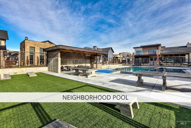 view of swimming pool featuring a yard, a patio area, and fence