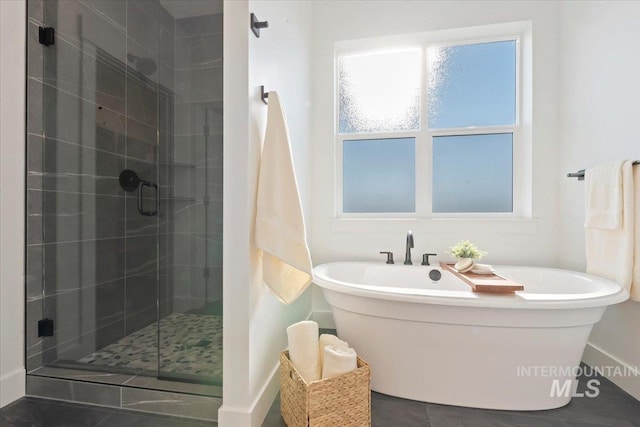 2394 E Monhegan Dr, Eagle, ID 83616 - bathroom featuring a shower stall, a soaking tub, baseboards, and tile patterned floors