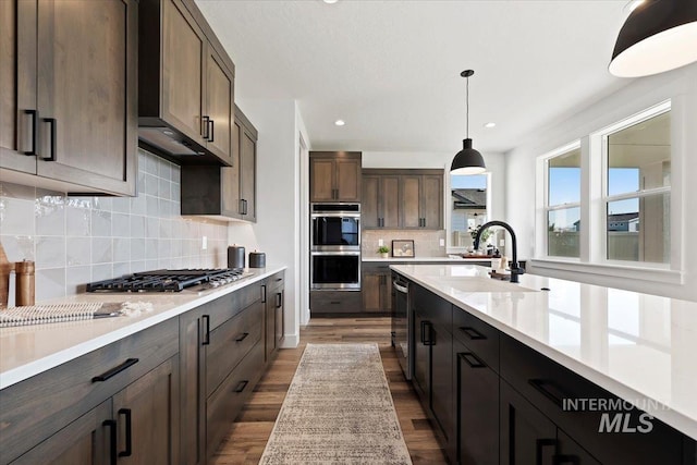2394 E Monhegan Dr, Eagle, ID 83616 - kitchen featuring a sink, appliances with stainless steel finishes, light countertops, dark wood-style floors, and backsplash