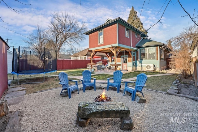 back of house with a patio area, ac unit, a fire pit, and a trampoline