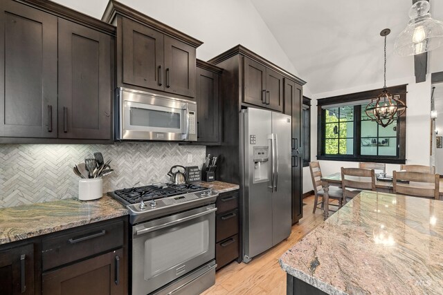 1520 Roosevelt Ave, Mccall, ID 83638 - kitchen with appliances with stainless steel finishes, vaulted ceiling, tasteful backsplash, a chandelier, and dark brown cabinetry