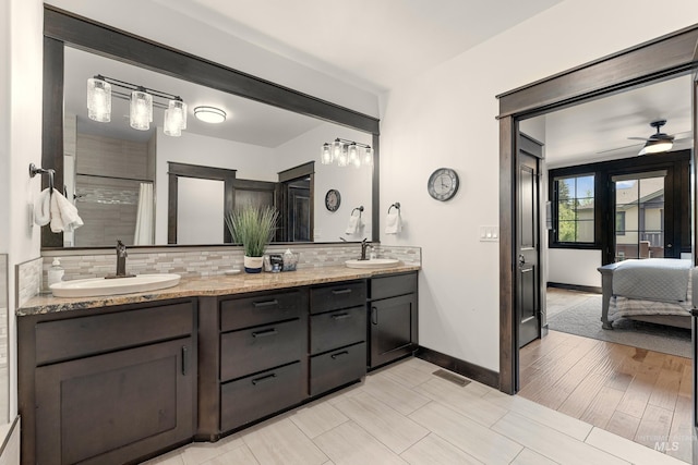 1520 Roosevelt Ave, Mccall, ID 83638 - bathroom featuring tasteful backsplash, double vanity, baseboards, a ceiling fan, and a tile shower